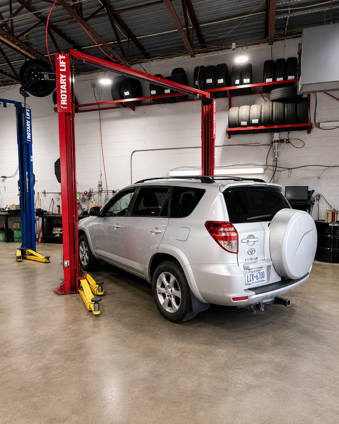 Vehicle raised on hydraulic lift inside Browncroft Auto Service Center's repair bay in Rochester, NY